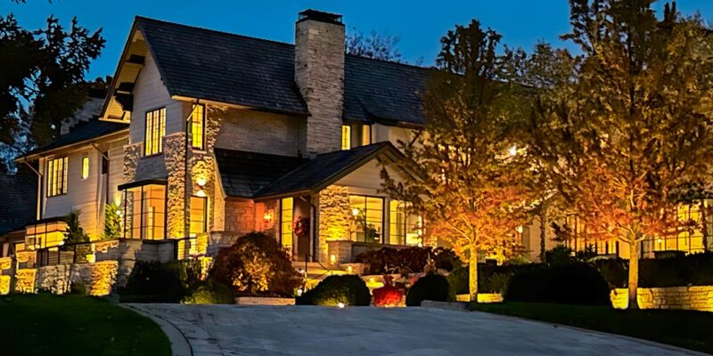 luxury home with landscape lighting at dusk