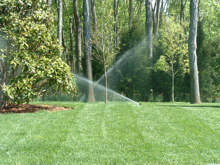 irrigation system watering a green field of grass
