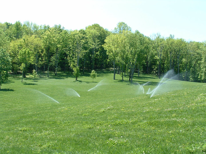 irrigation system watering a green field of grass