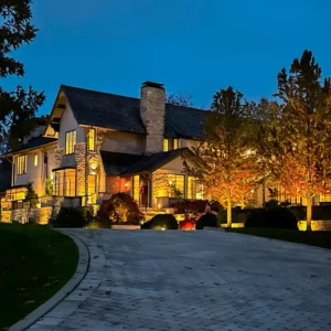 A beautiful home at dusk with outdoor lights illuminating architecture and landscape.