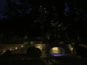 A bocce court is lit by a professional landscape lighting system